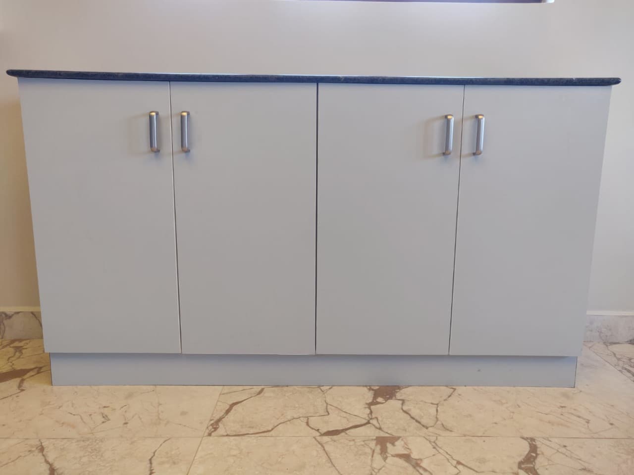Fitted storage cabinet finished in grey laminate with a polished granite top