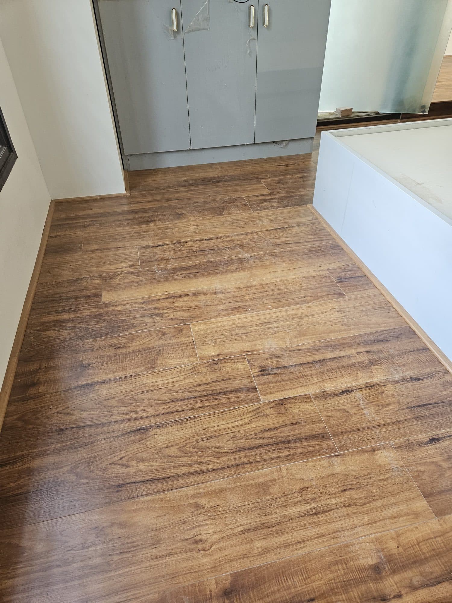 Laminate planks laid across a hall, staggered so the pattern does not repeat